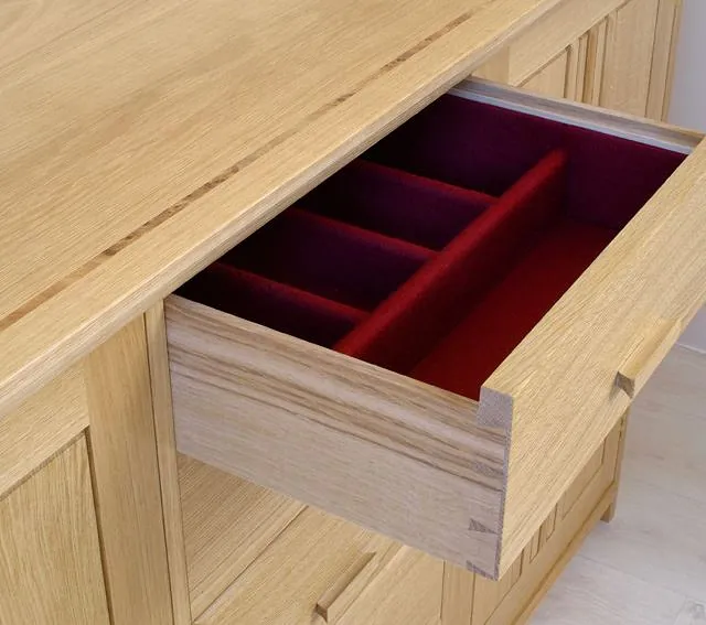 wooden drawer open with red felt lining 